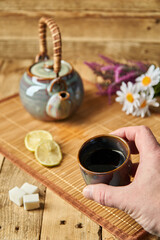 Chinese tea party. A fancy colored ceramic teapot and teacup set against a mat next to sugar, limes...