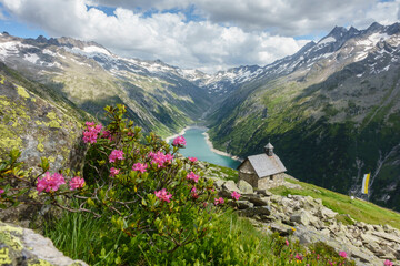 Blick zu einer Bergkapelle mit See im Hintergrund
