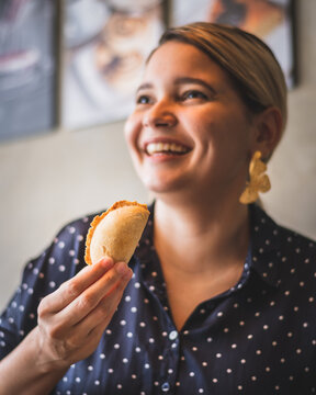 Woman Eating An Empanada