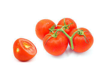 Fresh ripe organic tomatoes on a branch and a half of a tomato in drops of water isolated on a white background.