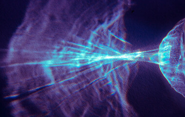 Naklejka premium A beautiful photo of a sunbeam on paper. The beam passes through a glass glass with water and is reflected on the paper