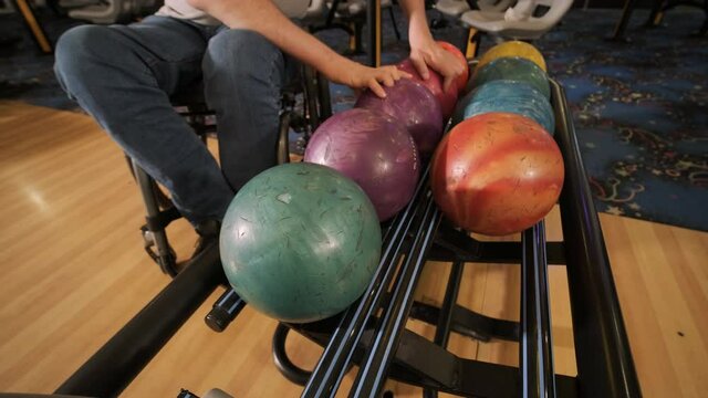Two young disabled men in wheelchairs playing bowling in the club