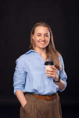 Photo of business woman with cup, looking at camera and smiling.