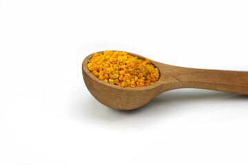 Pile of bee pollen in a wooden spoon isolated on white.
