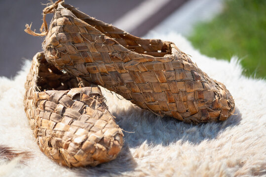 Old wicker bast shoes made of wood.