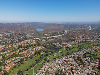 Aerial view of residential neighborhood surrounded by golf and valley during sunny day in Rancho...