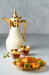 Baklava sweets with Arabic Coffee pot Dallah and cup of traditional  cardamon coffee  Qahwa