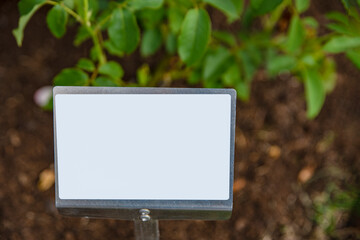 Empty sign in the vegetable garden. Plate for price or text insertion.