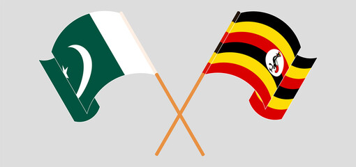 Crossed and waving flags of Pakistan and Uganda