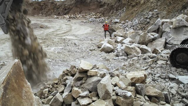Foreman giving instructions to excavator on quarry