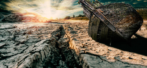 Dried, battered from drought land, dried up river, abandoned destroyed boat from time to time. Rays...