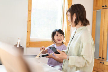 Obraz premium お母さんと一緒に料理をする小さな女の子