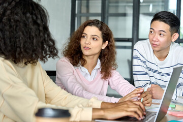 Serious concentrated multiethnic diverse young creative team students group talking brainstorming...