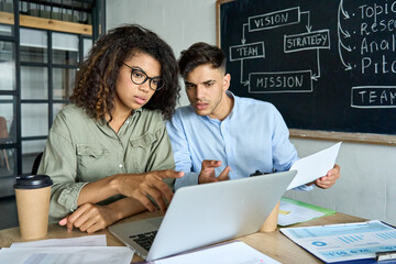Young focused creative team diverse international startup coworkers students African American girl...