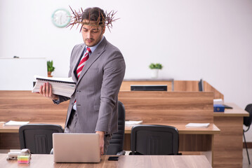 Young male employee wearing prickly wreath on head