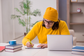 Young male student preparing for exams at home