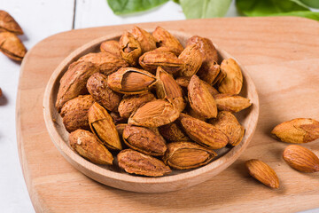 Delicious roasted sweet almonds nuts on wood background