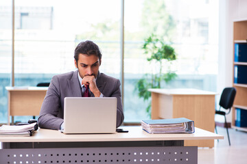 Fototapeta premium Young male employee working in the office