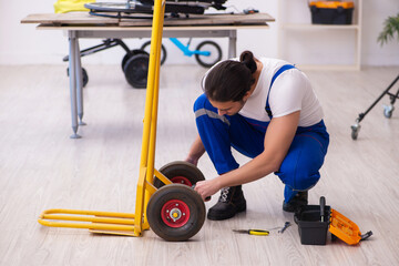 Young male repairman repairing trolley indoors