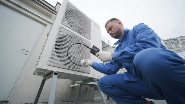 The technician uses a digital camera to check the clogging of the heat exchanger