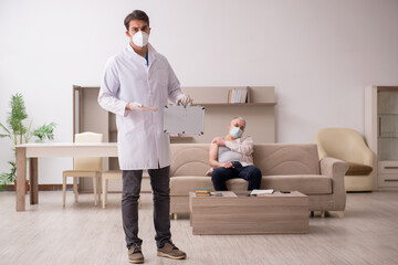 Young male doctor visiting old patient in vaccination concept