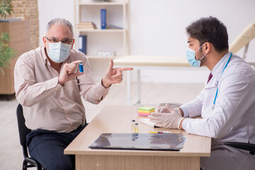 Old male patient visiting young male doctor in vaccination conce