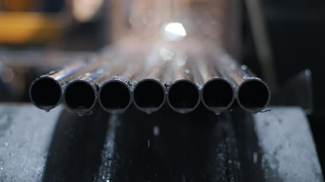 Cutting stainless steel pipes, the band saw for industrial cutting the metal stainless pipe and using the coolant heating. The industrial tool.