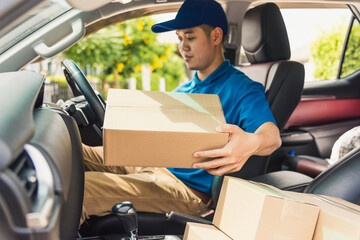 Asian young delivery man courier in uniform hold documents clipboard checking list parcel post boxes inside a car for service shipment to customer, Online shopping service concepts