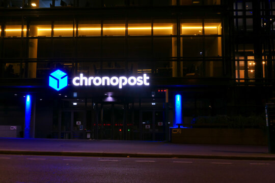 Paris, France. July 10. 2021. Neon light sign then night on building with the sign of a parcel delivery company. Chronopost logo.
