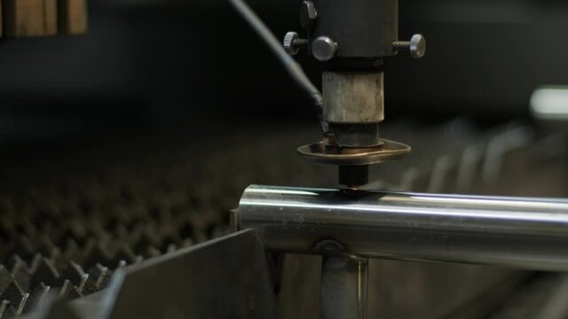 Modern industrial laser machine with CNC, Metal cutting technology. Laser cutting of steel pipes in a modern factory. Laser cuts holes in the pipe.
