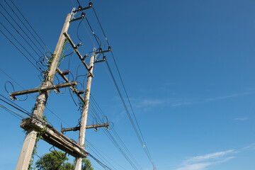 High electric voltage  post without transformer on blue background.Electric post is covered by ivy.
