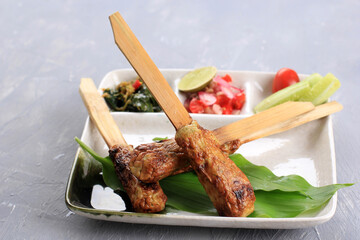 Sate Lilit, Traditional Balinese Minced Seafood or Chicken Satay with Bamboo Skewer. Sometimes Suing Lemongrass as Aromatic Skewer. Served on Table with another Balinese Side Dish - obrazy, fototapety, plakaty