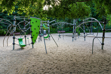 Children's playground with sandy ground and green plants. Retiro Park Madrid.