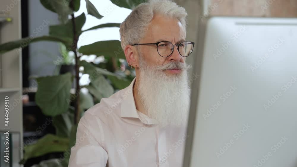 Sticker Mature businessman working on computer in modern office. Slow motion.