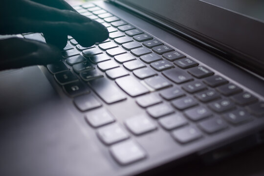 Blur image of finger typing keyboard laptop computer. hacker steal information. identity theft, violation database in server organization,Hacker, virus release for destroy system program concept.