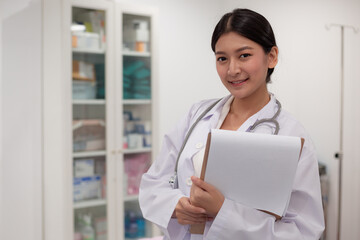 Asian Female Doctor With Stethoscope On Her Neck And Clipbroad In Her Hands,Doctor Stand in office
