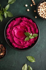 Humus Bowl. Red beetroot hummus with fresh vegetables, olive oil on table