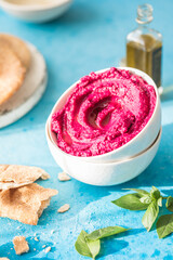 Humus Bowl. Red beetroot hummus with fresh vegetables, olive oil on table