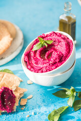 Humus Bowl. Red beetroot hummus with fresh vegetables, olive oil on table