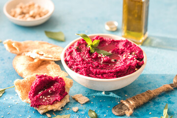 Humus Bowl. Red beetroot hummus with flatbread, olive oil on table