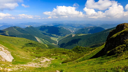 Fototapeta na wymiar Green mountain ridge in nice weather, with blue sky and white clouds. Mala Fatra