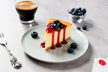Dessert - piece of New York Cheesecake with blueberry sauce and fresh berry.