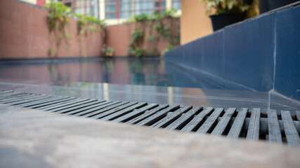 Swimming pool gutter closes up, water surface low angle view.
