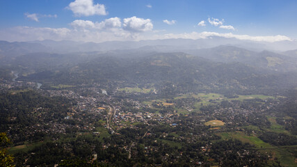 Panoramic view from Ambuluwawa tower, a distant misty mountain range with small towns and villages aerial view.