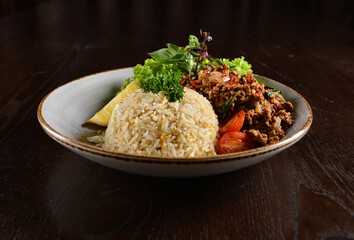 Thai style egg fried rice with spicy minced meat quorn and sliced of lemon asian vegetarian menu on wood table