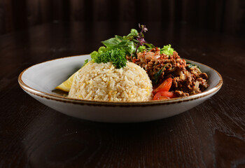 Thai style egg fried rice with spicy minced meat quorn and sliced of lemon asian vegetarian menu on wood table