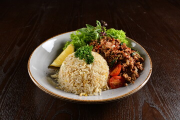 Thai style egg fried rice with spicy minced meat quorn and sliced of lemon asian vegetarian menu on wood table