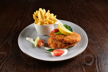 deep fried golden chicken meat / quorn vegetarian / fish fillet seafood steak with French fries and vegetables in lemon creamy sauce on wood background western menu