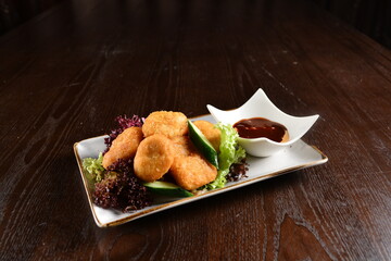 deep fried golden crispy chicken or fish nugget with homemade sauce on wood table snack Halal menu