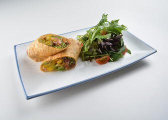 vegetarian pan tortilla wrapped with salad and dressing on white background vegan halal menu